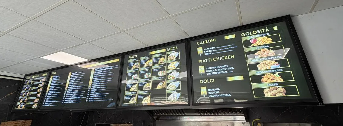 Quattro pannelli menu luminosi a fondo nero in un locale